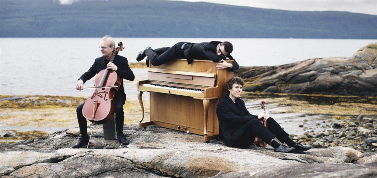 Piano og musikere på svaberg ved fjorden